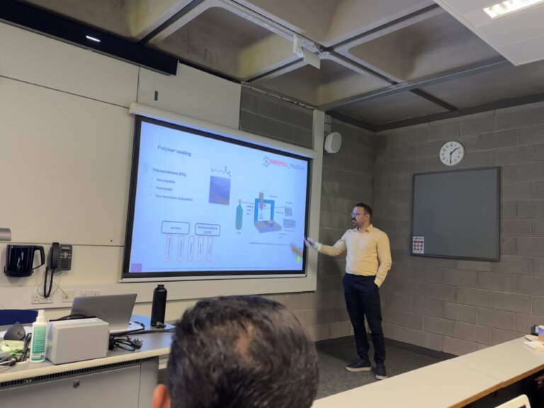 Masih presenting his research on 4th March 2024. He is pointing to the projected research slides